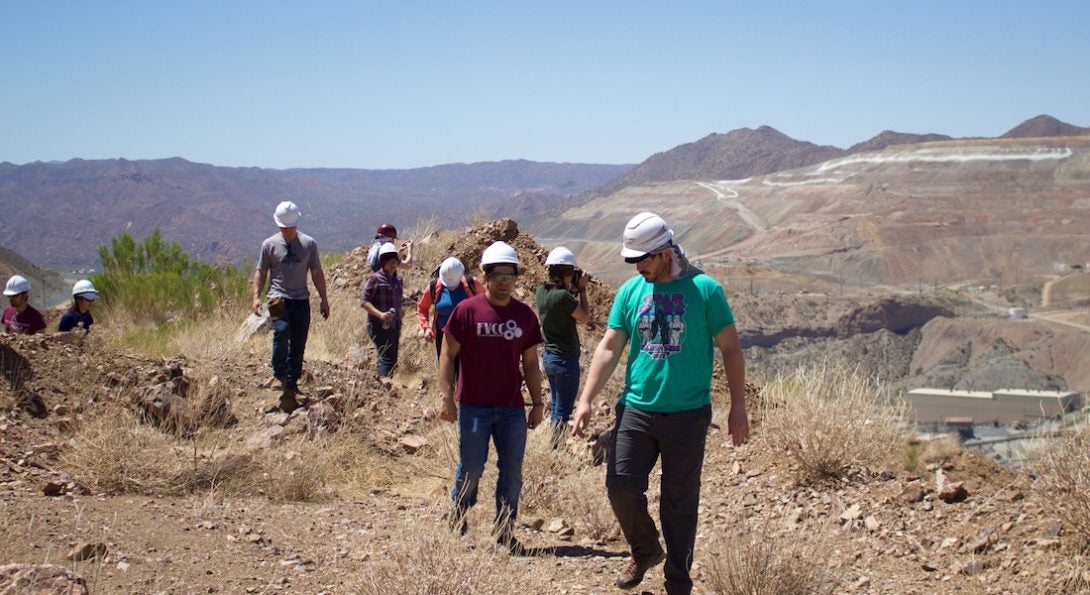 Students in hard-hats looking into a quarry in the distance