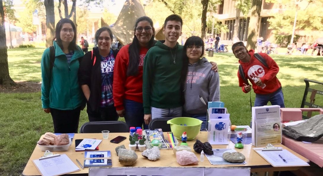 Terra Society members outside on UIC's campus in front of a tabling booth.