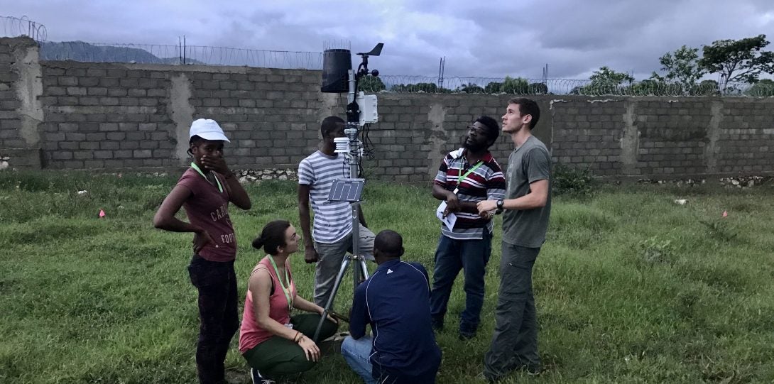 Group of scientists looking at a meteorological station