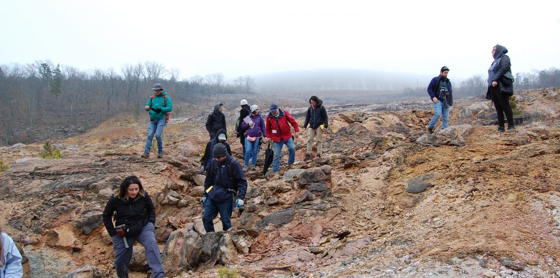 Group of students scattered along a rocky outcrop.